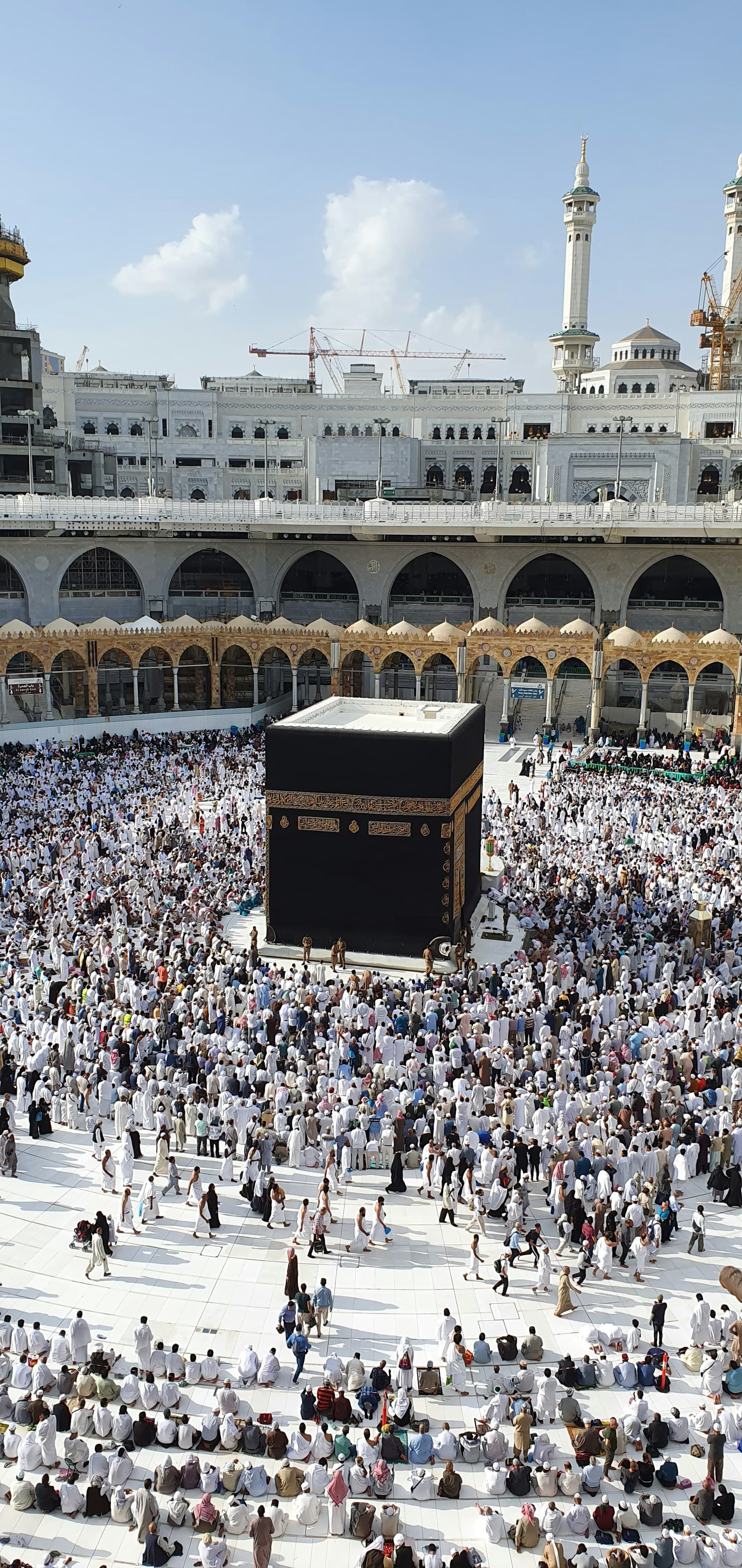 The Kaaba surrounded by pilgrims in white, seen from the upper floors of Masjid al-Haram